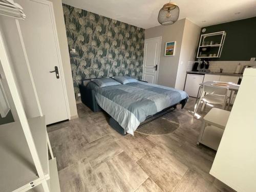 a bedroom with a bed and a kitchen at Nid Catalan Climatisé Jardin Centre-ville Plage in Perpignan