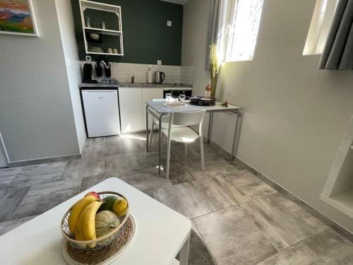 a kitchen with a basket of fruit on a table at Nid Catalan Climatisé Jardin Centre-ville Plage in Perpignan