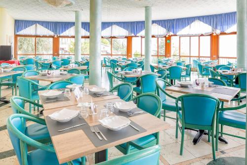 a dining room with blue tables and chairs at Centro Vacanze La Limonaia in Limone sul Garda