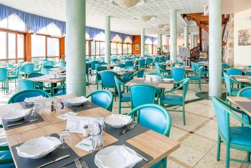 a dining room with wooden tables and blue chairs at Centro Vacanze La Limonaia in Limone sul Garda