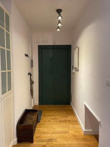 a hallway with a green door and a wooden floor at Family apartment on Saska Kępa in Warsaw