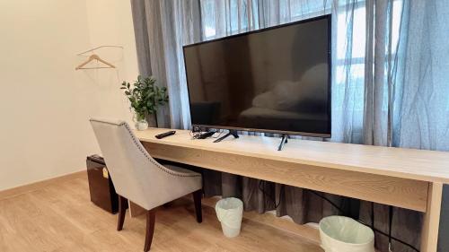 a desk with a television on top of it at La Moon House in Salaya
