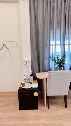 a room with a table and a chair and a window at La Moon House in Salaya