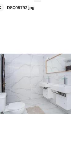bagno bianco con servizi igienici e lavandino di Faustina's room a Portimão