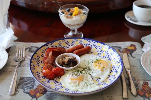 a plate of eggs and sausage on a table at Mt Horeb Manor in Clarens