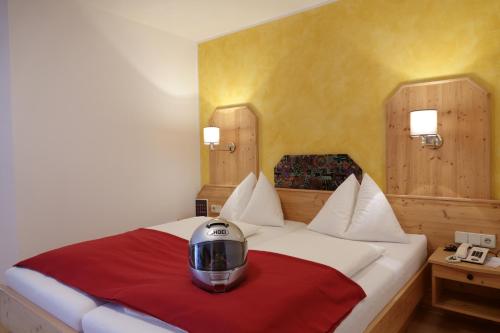 a bedroom with a bed with a helmet on it at Hotel Malteinerhof in Malta
