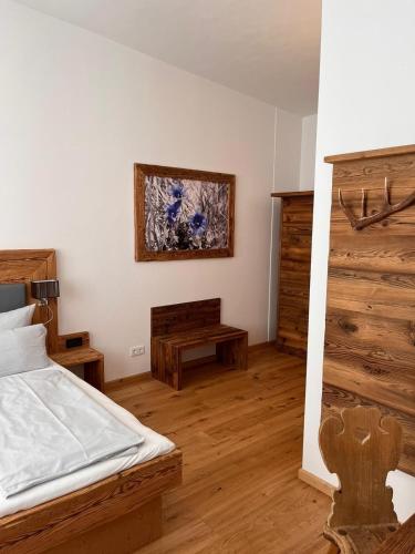 a bedroom with a bed and a wooden floor at Hotel Almwirt in Haar