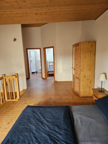 a bedroom with a bed and a wooden floor at Ferienwohnungen Das Finkhaus in Simonsberg