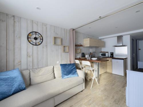 un salon avec un canapé et une cuisine dans l'établissement Studio confort rénové, balcon sud, skis aux pieds - FR-1-181-2556, à Aime La Plagne