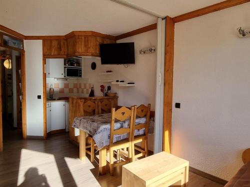 une cuisine avec une table et une petite cuisine avec une table et des chaises dans l'établissement Studio cosy sur les pistes avec balcon - FR-1-181-2581, à Aime La Plagne