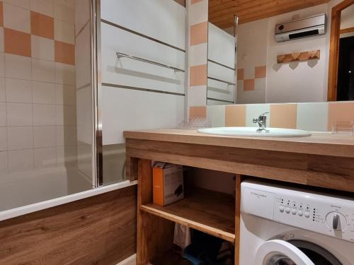 une salle de bain avec un lavabo et une machine à laver dans l'établissement Studio cosy sur les pistes avec balcon - FR-1-181-2581, à Aime La Plagne