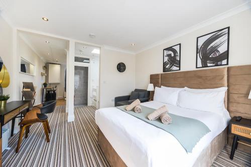 a bedroom with a large white bed and a desk at Islington Quarter in London