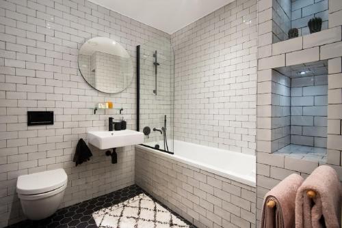 a bathroom with a sink and a toilet and a tub at 1 The Bay - Stunning contemporary flat on the Scottish coast in Coldingham