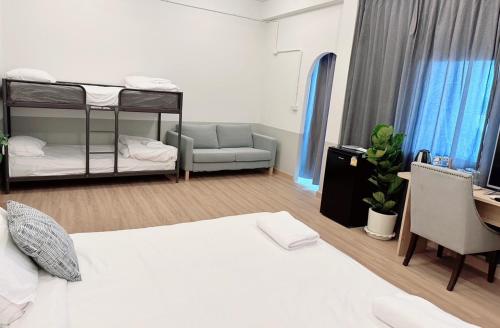 a bedroom with two bunk beds and a desk at La Moon House in Salaya