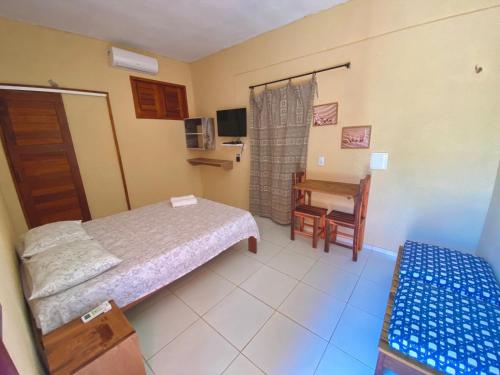 a bedroom with a bed and a desk and a chair at Pousada Recanto dos Parente - Icaraizinho de Amontada in Amontada