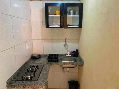 a kitchen counter with a stove and a sink at Pousada Recanto dos Parente - Icaraizinho de Amontada in Amontada