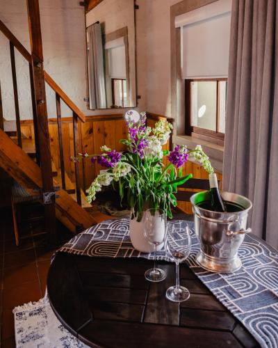 a table with a vase of flowers on a table at Anglers Court in Dullstroom
