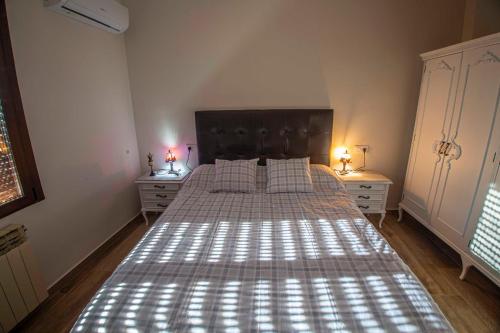 a bed in a bedroom with two dressers and two lamps at AT la abuela Antonia- Ca Pablo in Torre de Don Miguel