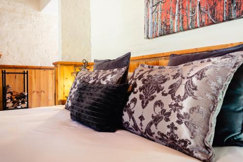 a bed with four pillows on top of it at Anglers Court in Dullstroom