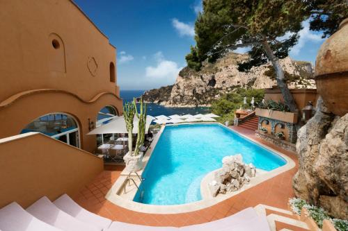 a resort pool with a view of the ocean at Hotel Punta Tragara in Capri