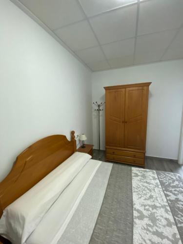 a bedroom with a large bed and a wooden cabinet at Apartamento Gabarron in Mula