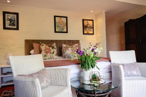 a bedroom with a bed with a glass table and chairs at Anglers Court in Dullstroom