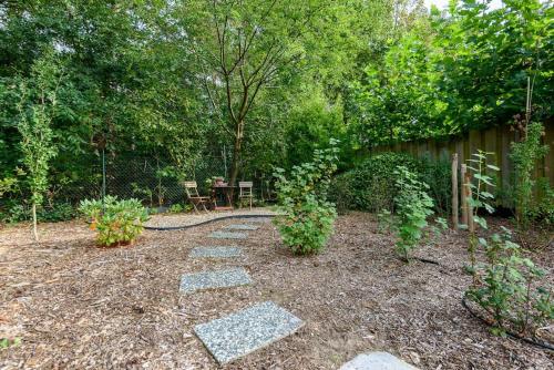 a patio with a table and chairs in a garden at Spacious wooden cottage with infra-red sauna at Veluwe in Putten