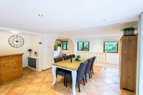 a kitchen and dining room with a table and chairs at Spacious wooden cottage with infra-red sauna at Veluwe in Putten