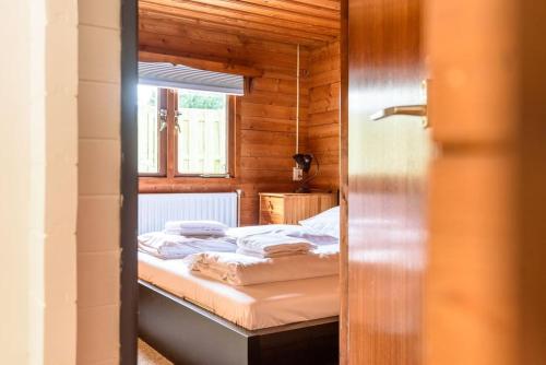 una camera da letto con letto in una camera in legno di Spacious wooden cottage with infra-red sauna at Veluwe a Putten