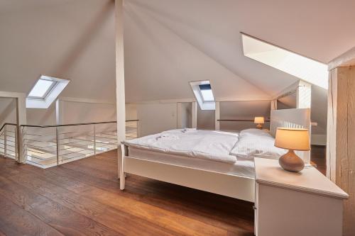 a white bedroom with a bed and two skylights at City Apartment Bern, perfect located and spacious in Bern