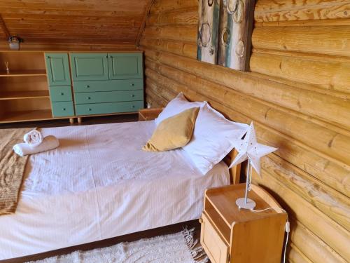 Lucky Rönk vendégház في Vîlcele: غرفة نوم مع سرير في كابينة خشب