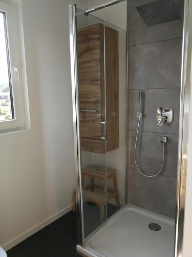 La salle de bains est pourvue d'une douche avec une porte en verre. dans l'établissement Gästezimmer mit eigenem Bad in Reihenmittelhaus, à Feucht