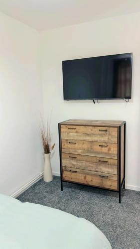 a flat screen tv sitting on top of a wooden dresser at 7 Venus Road Room 2 in London
