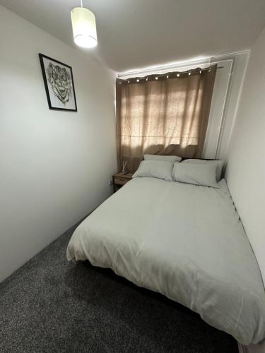 a bedroom with a white bed and a window at 7 Venus Road Room 2 in London