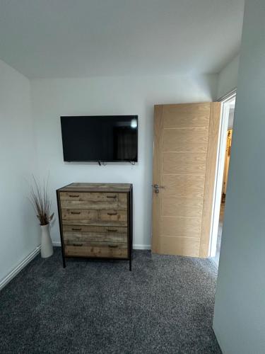 a room with a dresser and a flat screen tv on a wall at 7 Venus Road Room 2 in London