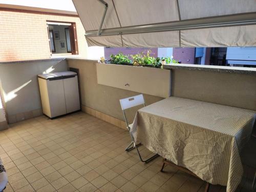 balcón con mesa y ventana con plantas en Accogliente monolocale con piscina, en Caronno Pertusella