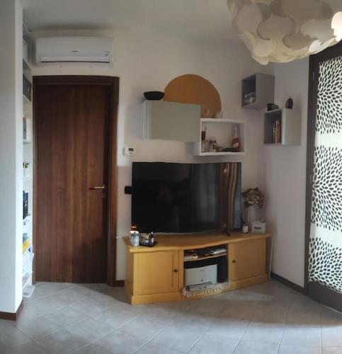 una sala de estar con TV en un centro de entretenimiento de madera en Accogliente monolocale con piscina, en Caronno Pertusella