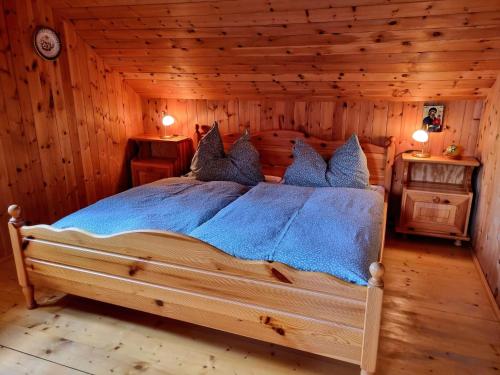 um quarto com uma cama num chalé de madeira em Alpine hut in St Lorenzen ob Murau Styria 