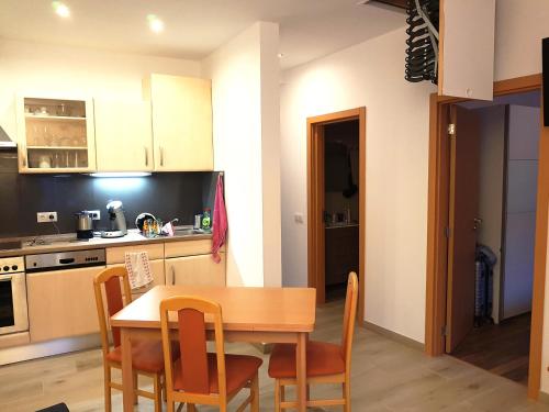 Il comprend une cuisine et une salle à manger avec une table et des chaises en bois. dans l'établissement CasaSanPaulo2, à Montijo