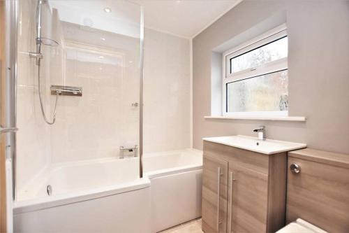 a bathroom with a tub and a sink and a shower at Stunning comfortable home from home in Millom