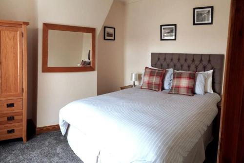 a bedroom with a large bed and a mirror at Stunning comfortable home from home in Millom