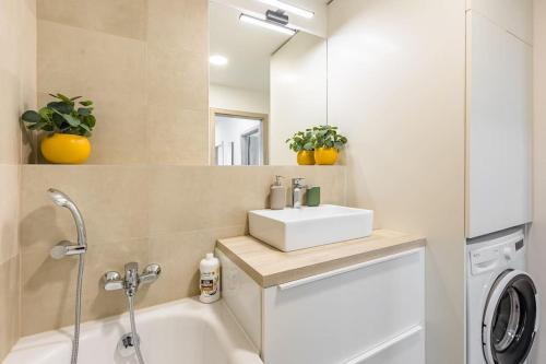 La salle de bains est pourvue d'un lavabo et d'une baignoire. dans l'établissement BNB Slovakia Ovocné sady Airport Apartment, à Bratislava