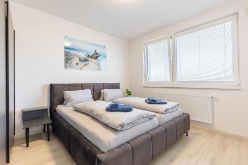 1 dormitorio con 1 cama grande y toallas azules. en BNB Slovakia Ovocné sady Airport Apartment en Bratislava