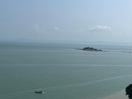 a boat in a large body of water with an island at Paradise by the Sea in Penang by Veron at Rainbow Paradise in Tanjung Bungah