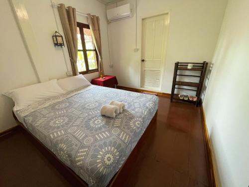 a bedroom with a bed with a stuffed animal on it at Moukdavan Guesthouse in Luang Prabang