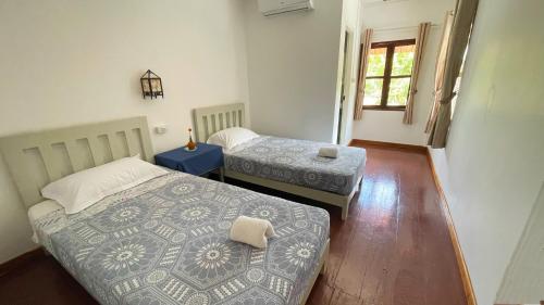 a room with two beds and a window at Moukdavan Guesthouse in Luang Prabang