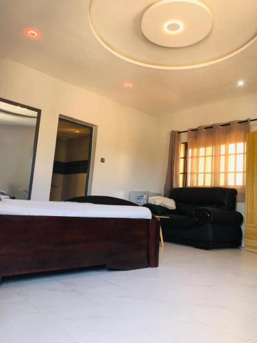 a bedroom with a bed and a couch at Beaca Maison d'Hôtes - BMH in Lomé