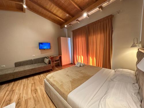 a bedroom with a bed and a couch and a tv at Arial Penthouse Suites in Vlorë