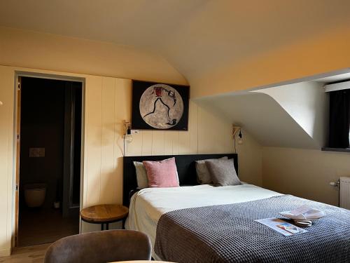 een slaapkamer met een bed en een klok aan de muur bij Good night Leuven -Self check-in in Leuven