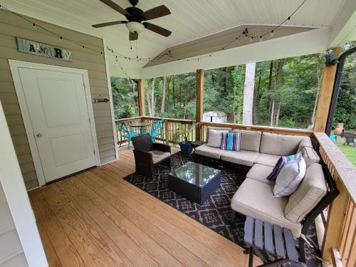 un porche grillagé avec un canapé et un ventilateur de plafond dans l'établissement Walkable Waxhaw, à Marvin